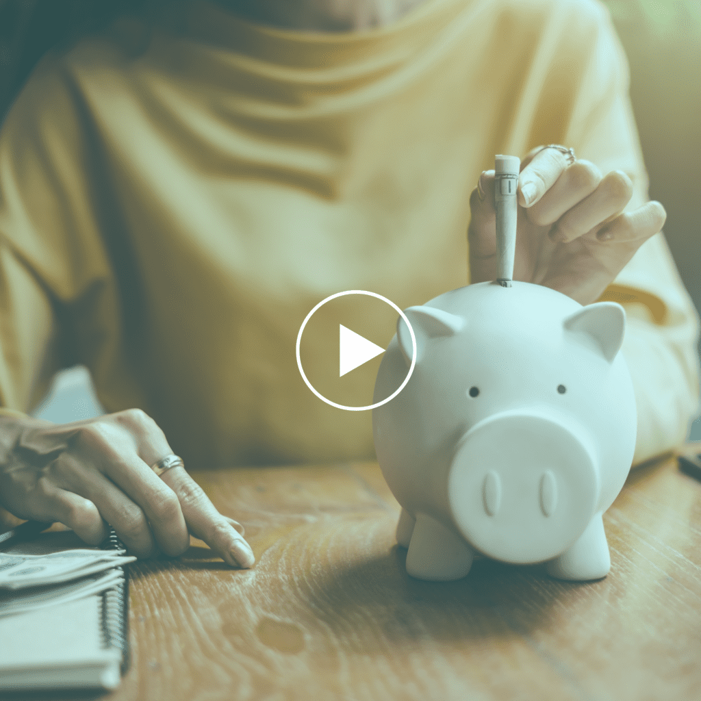 Woman putting money in a white piggy bank