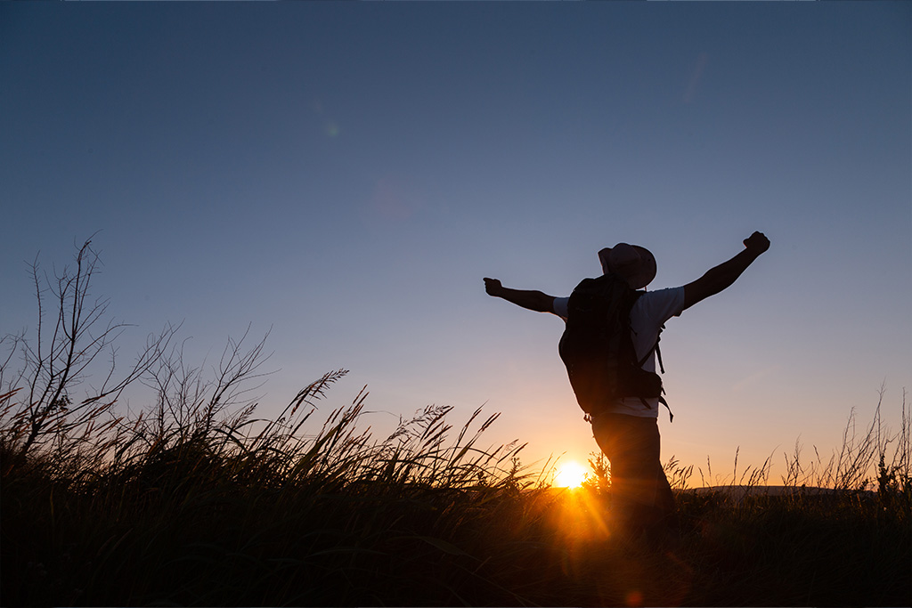 man expressing freedom in the sunset