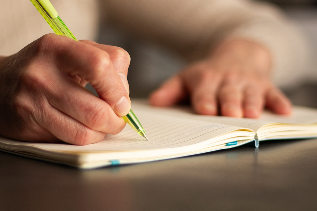 Person writing in notepad
